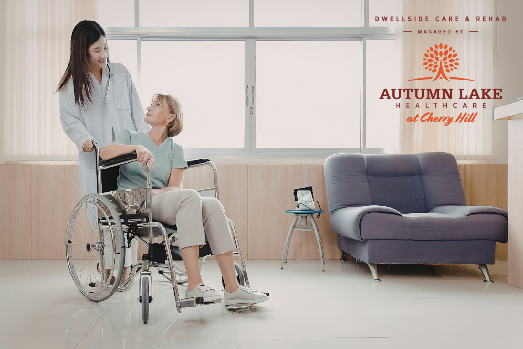 A healthcare worker pushing an elderly resident in a wheelchair at Autumn Lake Healthcare at Cherry Hill.